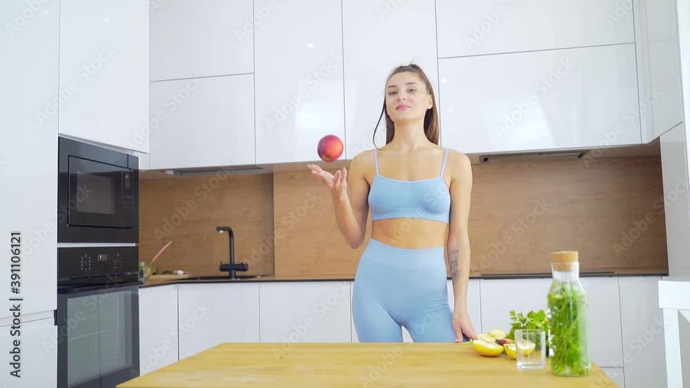 An apple a day keeps the doctor away. Portrait Happy smiling fit woman standing in the kitchen, holding fresh red apple and looking at camera. Healthy eating habits, dieting, weight loss concept, An apple a day keeps the doctor away. Portrait Happy smiling fit woman standing in the kitchen, holding fresh red apple and looking at camera. Healthy eating habits, dieting, weight loss concept,
