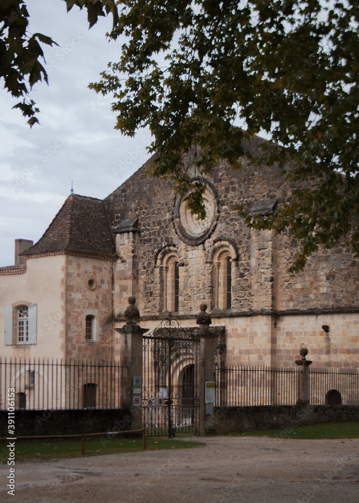 A view of an abbey. Facade with arch windows. Black fence along the historical building. Calm autumn day over the blue sky. Old stone architecture. A view of an abbey. Facade with arch windows. Black fence along the historical building. Calm autumn day over the blue sky. Old stone architecture.