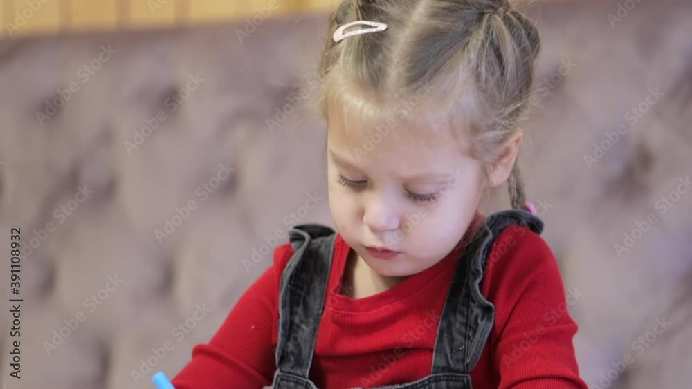 Portrait of a focused preschool girl painting with pencils. Art therapy Portrait of a focused preschool girl painting with pencils. Art therapy
