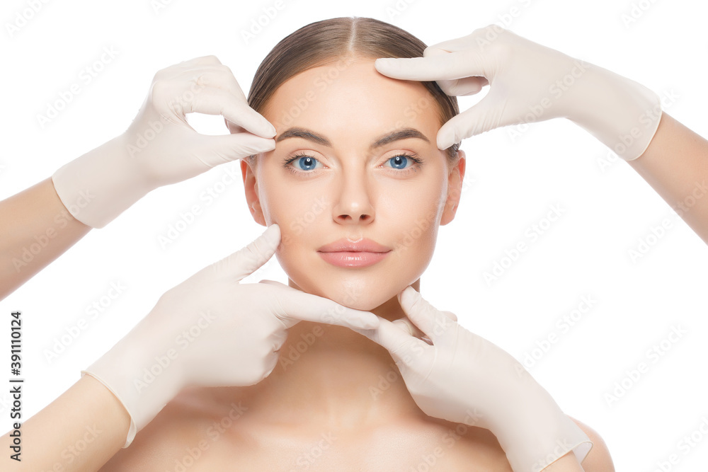 Portrait of young woman touched by doctors in gloves, preparing for plastic surgery, isolated on white background