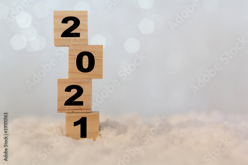 New year 2021 on wooden cubes on table with snow