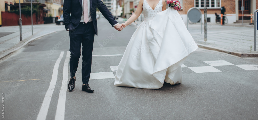 Wedding couple walking the street together celebrating happy wedding day. Wedding agency concept.
