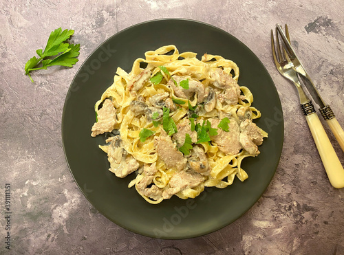 Pork tenderloin with creamy mushroom tagliatelle pasta and parsley. 