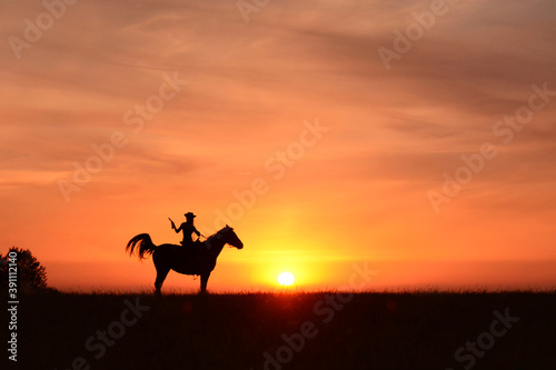 Fototapeta Naklejka Na Ścianę i Meble -  landscape, prairie, cowboy hat, horse silhouette, horse riding, sun, colt 45, cowgirl, cowboy, safari, wild, desert, rider, ride, girl, adventure, orange, beautiful, sunrise, travel, sky, sunset, hors