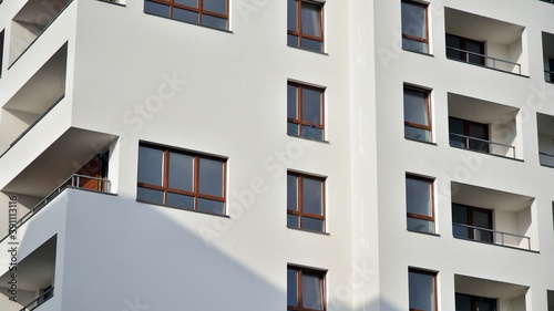 Exterior of a modern multi-story apartment building - facade, windows and balconies.
