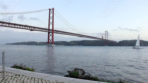 Big white sailboat on Tagus river with 25th of April Bridge on background in Lisbon, Portugal. Tourist attraction, vacation destination concepts photo