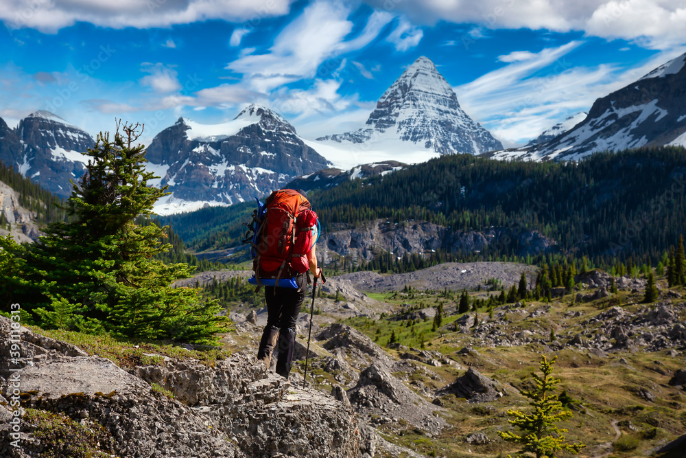 Adventure Backpacking in the Iconic Mt Assiniboine Provincial Park near Banff, Alberta, Canada. Blue Sky. Girl Hiker with Canadian Mountain Landscape in Background.