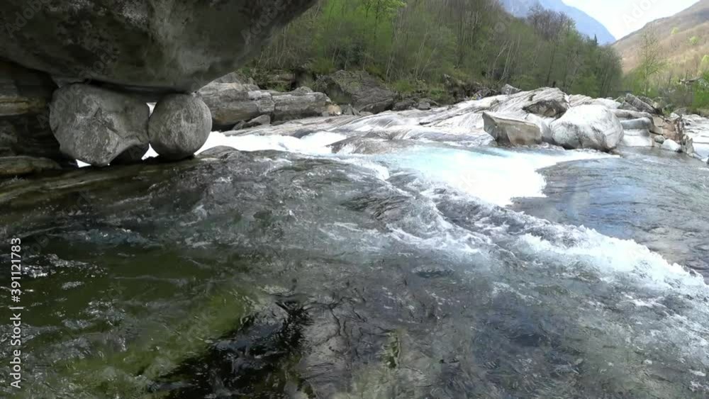 Rushing water in rapids of mountain pure river Verzaska in Switzerland. Fast flowing transparent waters and smooth rock. Ecotourism and pure nature on background of beautiful landscapes. Rushing water in rapids of mountain pure river Verzaska in Switzerland. Fast flowing transparent waters and smooth rock. Ecotourism and pure nature on background of beautiful landscapes.