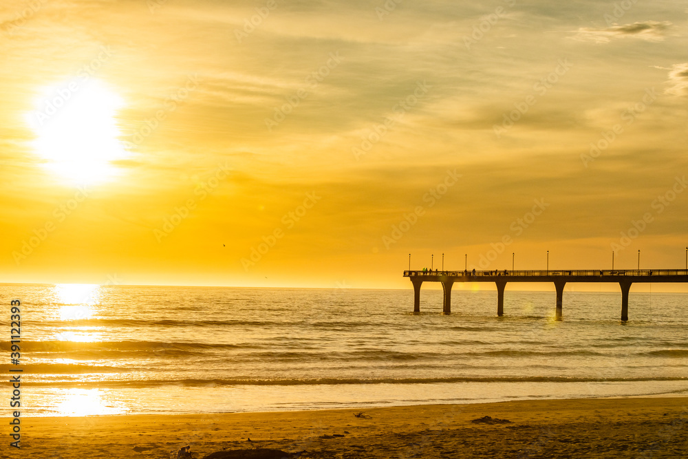 Sunset at the coast with a pier in New Zealand Sunset at the coast with a pier in New Zealand