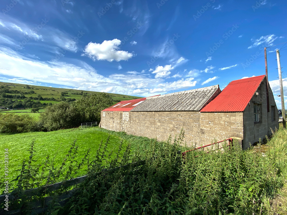 Building with a partially red roof on the, Straight Head Bank road, with hills and fields in the distance in, Nebiggin, Leyburn, UK