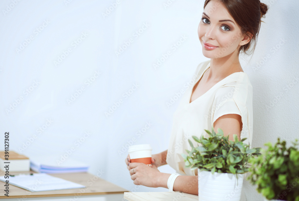 Attractive businesswoman standing near wall in office Attractive businesswoman standing near wall in office
