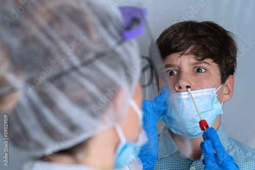 Taking sample for potential coronavirus from frightened patient                               photo