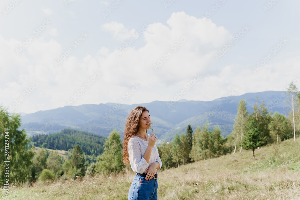 Naklejka premium Girl enjoying the mountain hills view. Feeling freedom in Karpathian mountains. Tourism travelling in Ukraine.