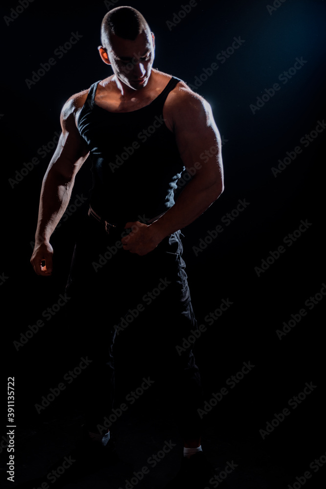 Bodybuilder flexing his muscles in studio