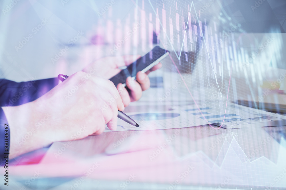 Double exposure of man's hands holding and using a phone and financial graph drawing. Analysis concept. Double exposure of man's hands holding and using a phone and financial graph drawing. Analysis concept.
