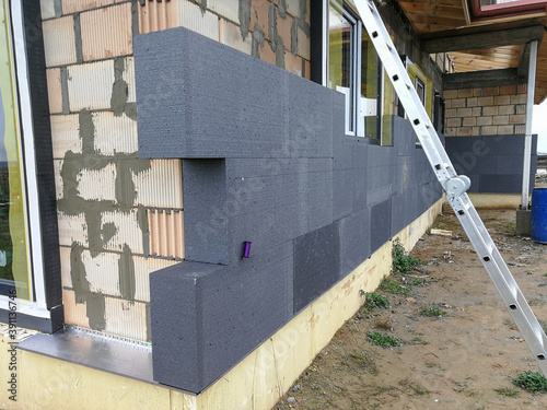 Black polystyrene foamboard on the house wall