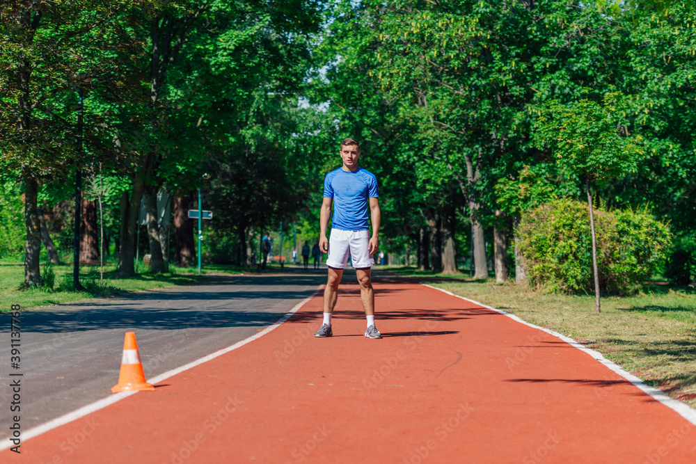 Young athlete standing on a running track in the park