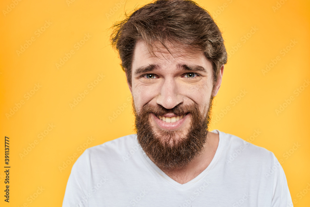 Man with emotional expression white t-shirt close-up studio yellow background Man with emotional expression white t-shirt close-up studio yellow background