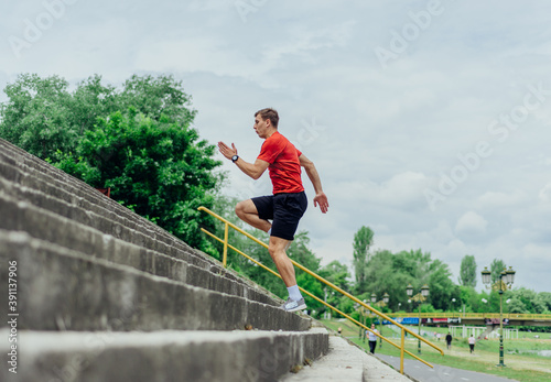 Fit male athlete performing stairs workout, running up climbing stairs performing outdoor track cardio.. © qunica.com