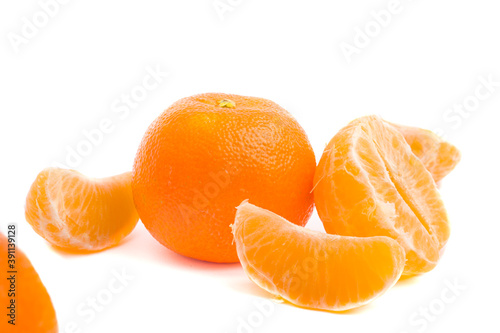 Mandarinas enteras y peladas con gajos sobre fondo blanco.