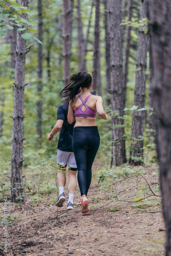 Fit male and female athletes running in nature. Nature and sports concept. Fit male and female athletes running in nature. Nature and sports concept.