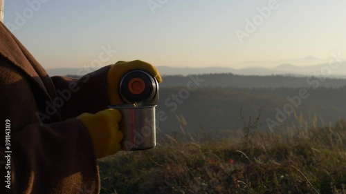 girl holding a cup of tea on a background of Beskides mountains photo