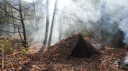 Survival Shelter Debris hut in the wilderness. Bushcraft camp setup in the forest.