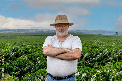 Portraid of middle-aged farmer with the blossom coffe plantation background, in Brazil photo