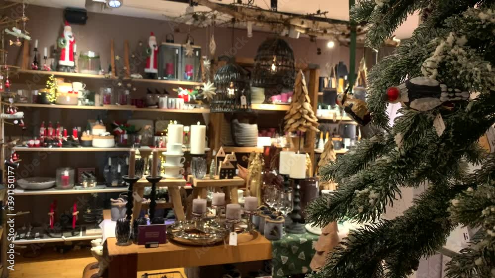 Snowy decorated Christmas fir tree in shop with santa claus gifts,candles and advent wreath for a beautiful interior home.Close up. Snowy decorated Christmas fir tree in shop with santa claus gifts,candles and advent wreath for a beautiful interior home.Close up.