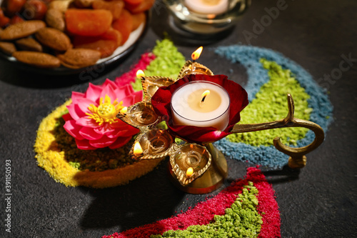 Festive composition with diya lamp for celebration of Divaly on dark background