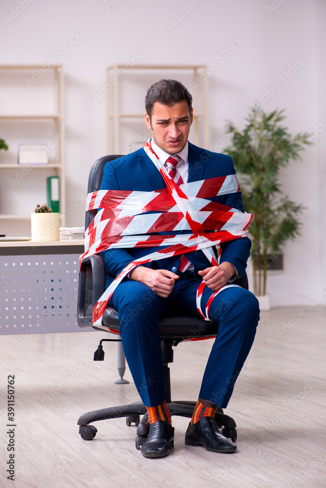 Tied male employee working in the office Tied male employee working in the office