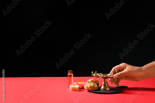 Female hand with diya lamp,...