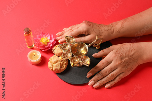 Female hands with diya lamp...