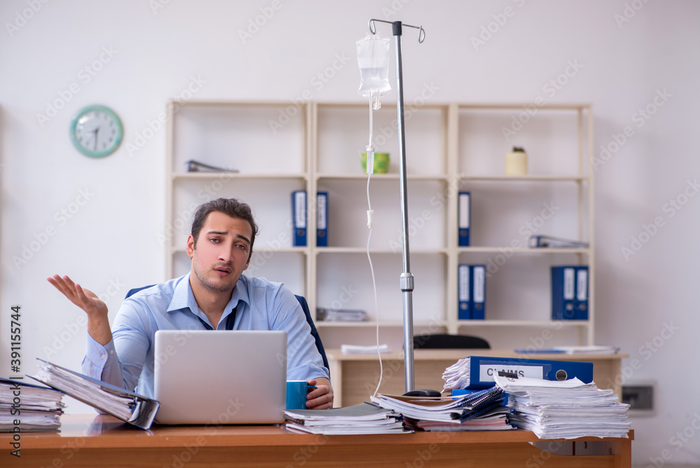 Young male employee suffering at workplace Young male employee suffering at workplace