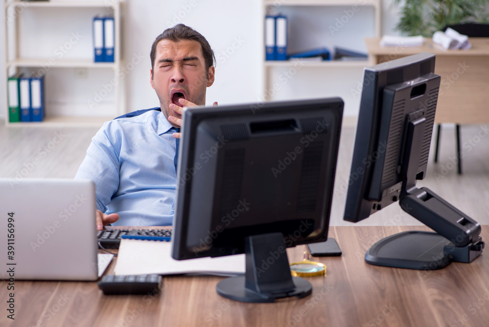 Young male employee unhappy with excessive work Young male employee unhappy with excessive work