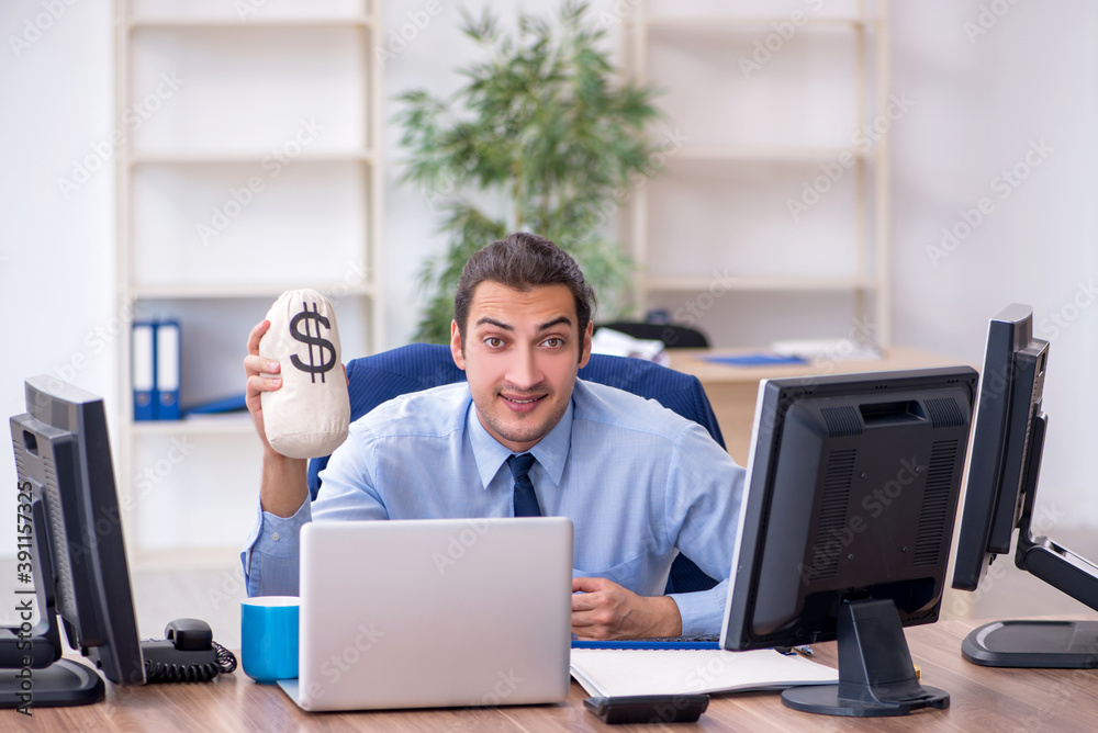 Young male employee holding moneybag in the office Young male employee holding moneybag in the office