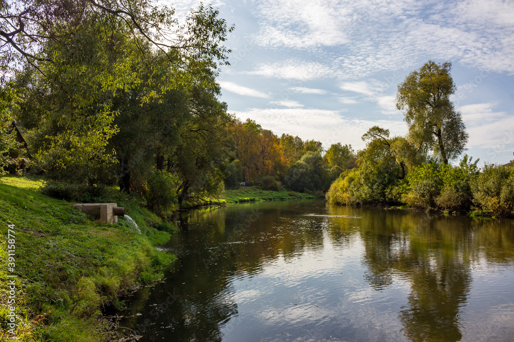Beautiful landscape with a river bank and water discharge from a pipe on the bank
Beautiful landscape with a river bank and water discharge from a pipe on the bank