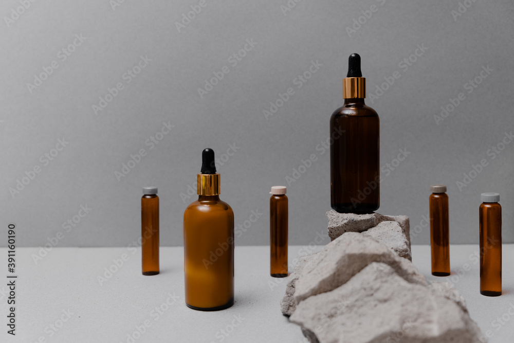Skin and body care concept. Trendy folded paper with textured rocks and cosmetics. Top horizontal view copyspace. Skin and body care concept. Trendy folded paper with textured rocks and cosmetics. Top horizontal view copyspace.