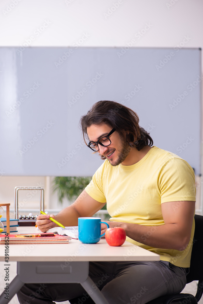 Young male student physicist preparing for exams in the classroo Young male student physicist preparing for exams in the classroo