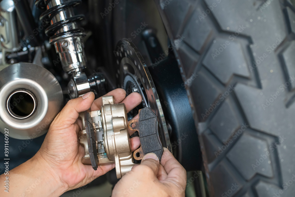 mechanic Replace and adjust motorcycle Rear Brake system,maintenance,repair motorcycle concept in garage .selective focus