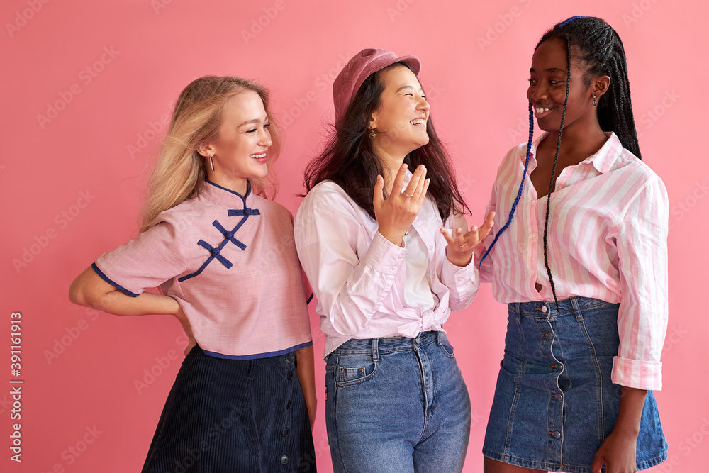 mixed race cheerful women friends posing with smile and have a fun on pink background, wearing trendy casual outfit mixed race cheerful women friends posing with smile and have a fun on pink background, wearing trendy casual outfit