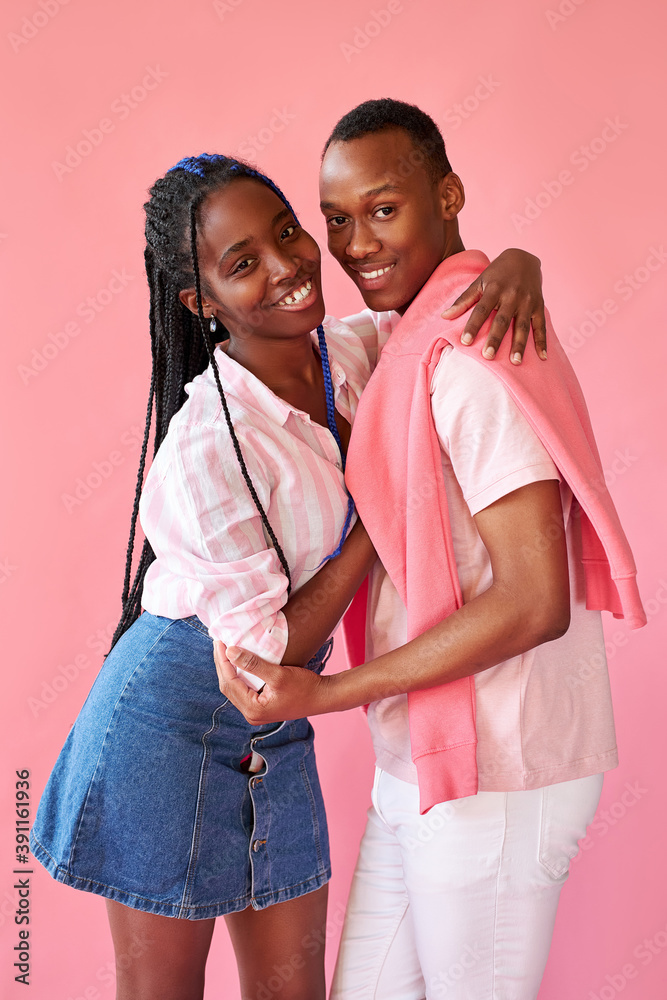 lovely positive african couple isolated over pink background, young man and woman in stylish wear are in love, posing together lovely positive african couple isolated over pink background, young man and woman in stylish wear are in love, posing together