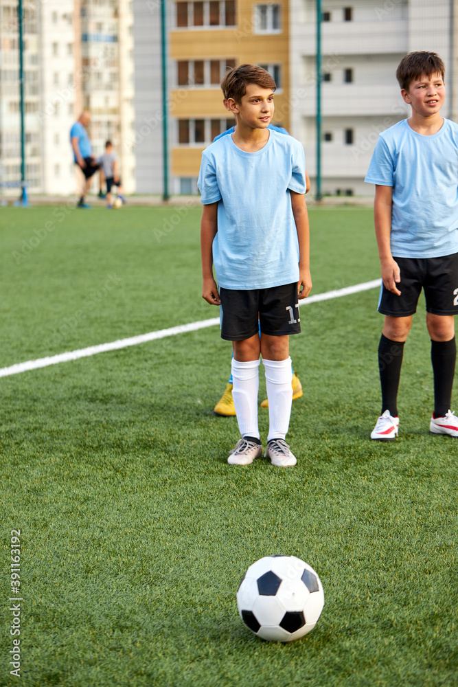 kids boys training with ball before sport competition, they are preparing for match in stadium, 8-9 years old children in unifrom