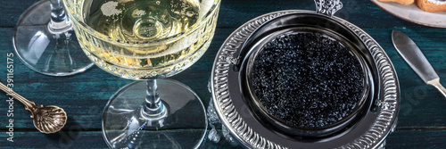 Champagne and caviar panorama. Vintage coupe glass and bowl, festive lifestyle header