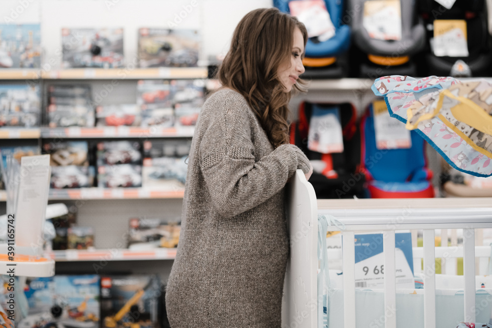 Young beautiful pregnant woman choosing baby stroller or pram buggy for newborn. Shopping for expectant mothers and baby. Pregnancy and newborn shopping Young beautiful pregnant woman choosing baby stroller or pram buggy for newborn. Shopping for expectant mothers and baby. Pregnancy and newborn shopping