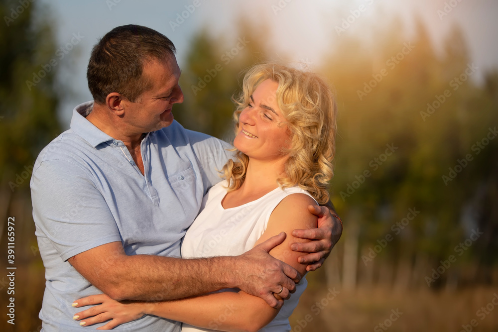Obraz premium A beautiful middle-aged couple in love hug and look at each other.