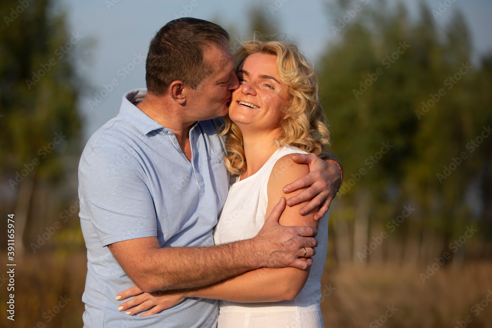 Fototapeta premium A beautiful middle-aged couple in love hugging and kissing.
