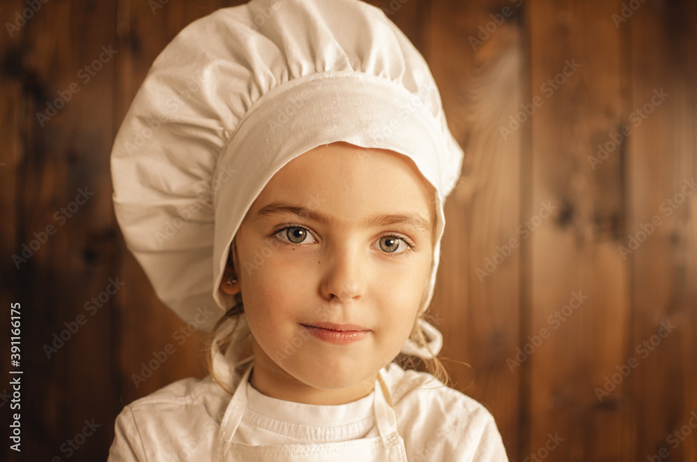 Close-up portrait of a child chef wearing a white chef's hat Close-up portrait of a child chef wearing a white chef's hat