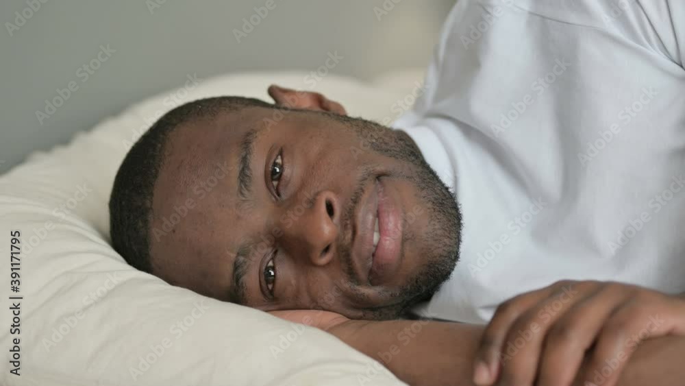 Young African Man in Bed Looking at Camera Young African Man in Bed Looking at Camera