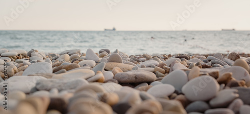 pebble beach at sunset. sea and ship in the background. Pebble close up.
